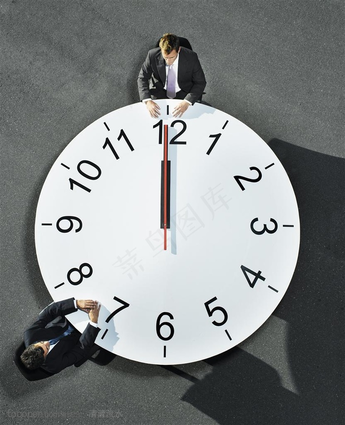 广告创意素材-坐在时钟桌子上洽谈的男人