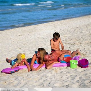 海滩休闲生活-沙滩上玩耍的一家人