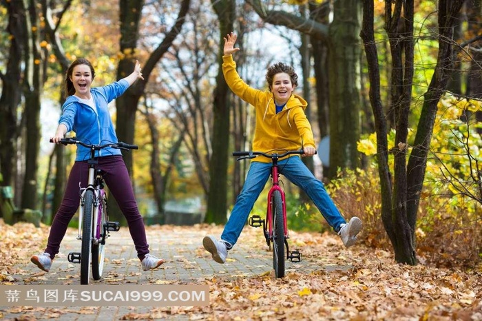 两个在户外骑自行车的学生