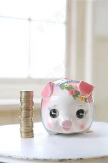 在一摞硬币旁边的小猪造型存钱罐高清摄影图片 在一摞硬币旁边的小猪造型存钱罐高清摄影图片