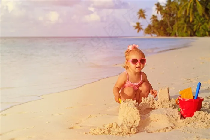 海边开心玩着沙子的小女孩