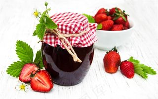 白色木板上的密封草莓果酱