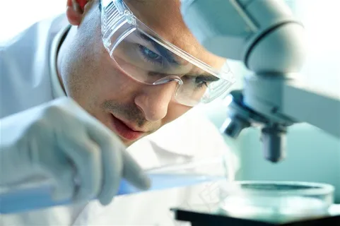 在显微镜钱观察工作的医务人员高清图片