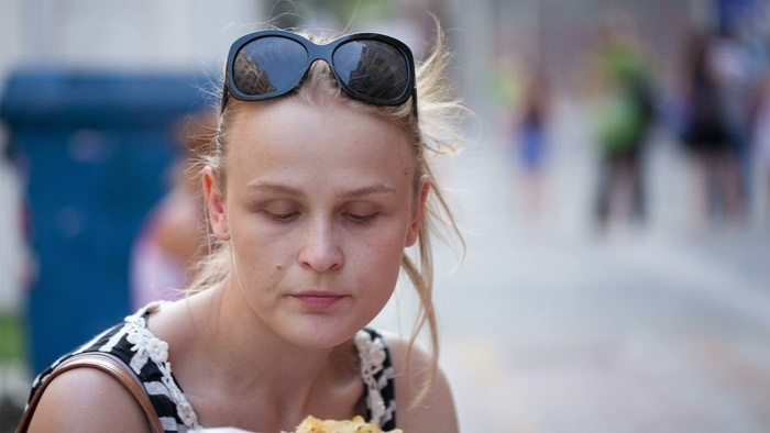 在街上吃快餐的女人