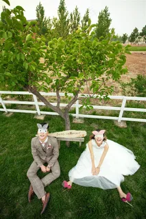 草地上坐着的带面具的情侣