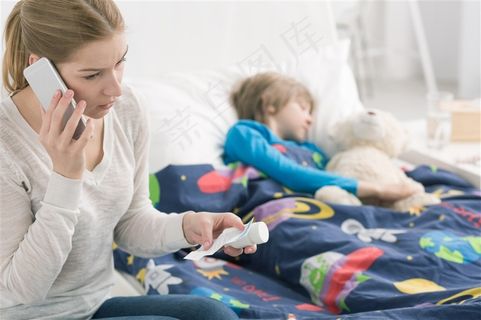 坐在孩子床边打电话的女性