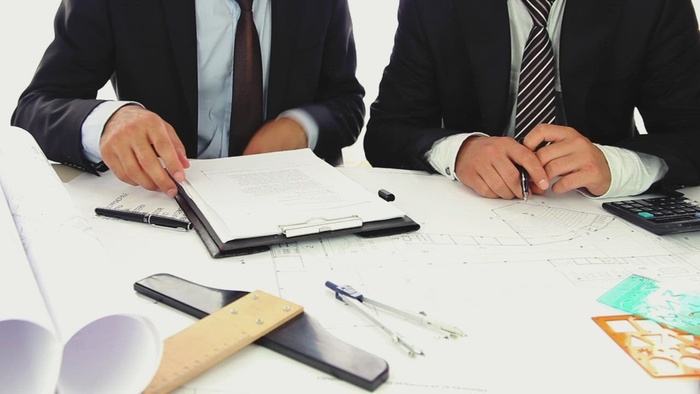 两个穿着西装的商人正在审查一些文件