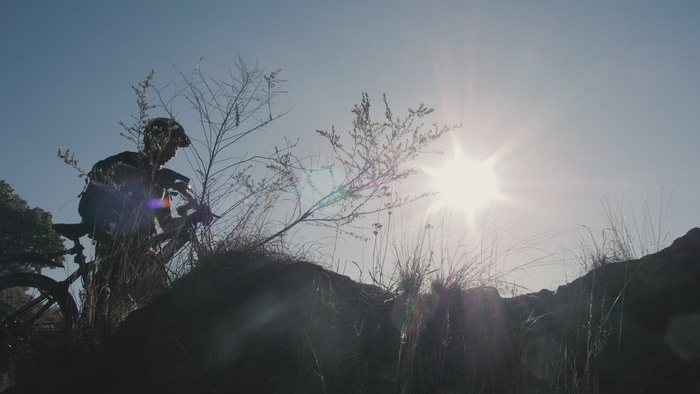 大自然中太阳前骑自行车者的剪影