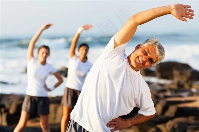 海边弯腰做运动的老年人