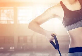 用力拉弹力带健身的美女高清图片