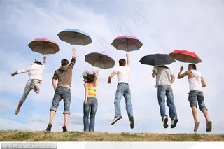 举着伞飞腾跳跃的人群
