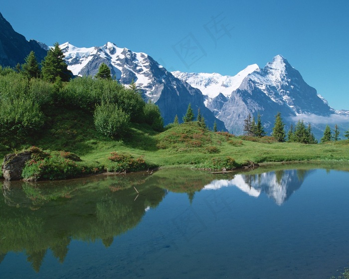 雪山下山坡前的平静湖面