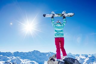 冬天举着滑雪板的人物