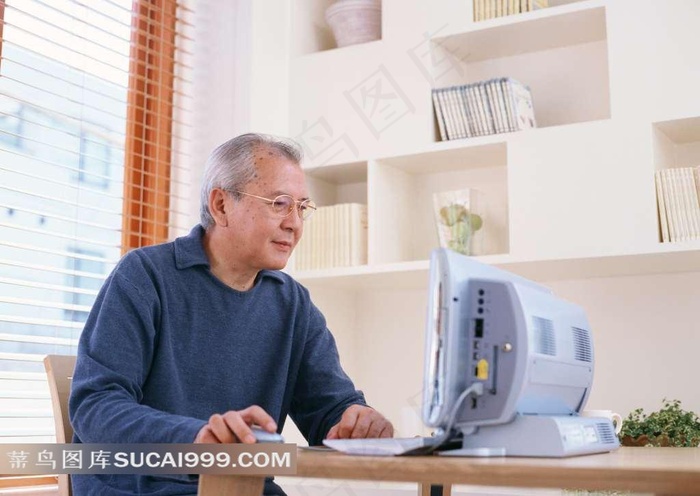 坐在桌边上网的老人