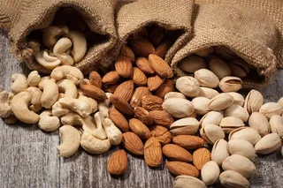 三个编织袋中散落的不同的果仁