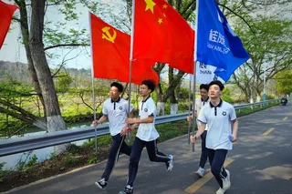 手持红旗奔跑的学生