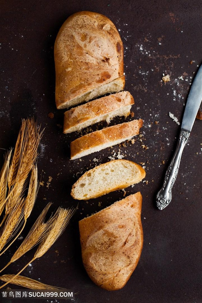 案板上放着几束小麦和切开的面包