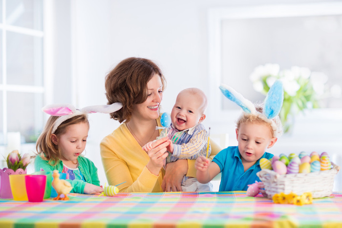 母亲带着三个孩子画复活节彩蛋