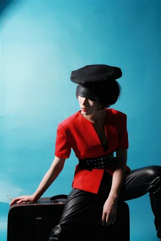 坐在皮箱上的红色少女