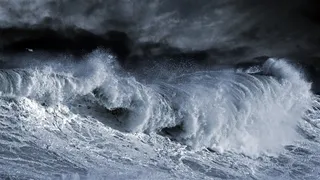 海面浪花与远处的黑云摄影高清图片