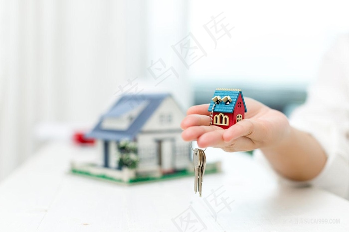 房子模型手托房子房地产经纪人与房屋模型钥匙