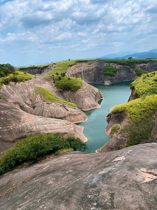 小山峰上的蓝天白云衬托出清澈的湖水