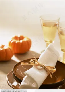 餐桌上的餐具、酒杯和收获的小南瓜