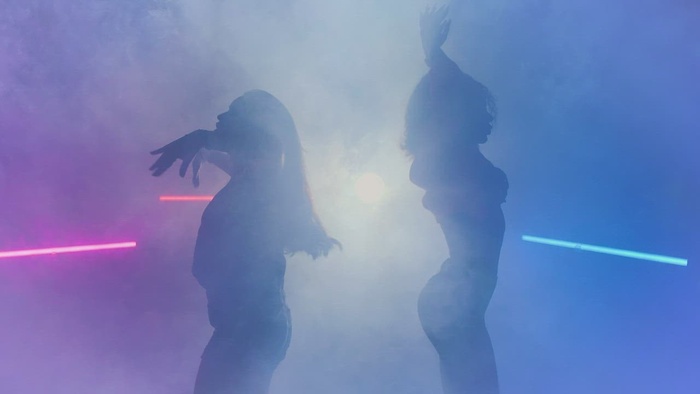 烟雾和彩灯下两名舞者的剪影