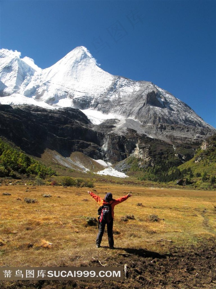 在雪山下张开双臂怀抱自然的旅行者