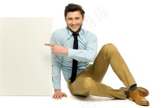 坐在地上指着广告牌的男士高清图片