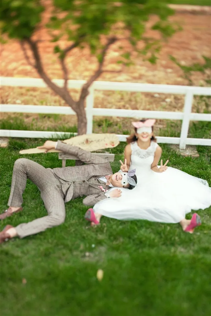 带面具的情侣躺卧在草地上