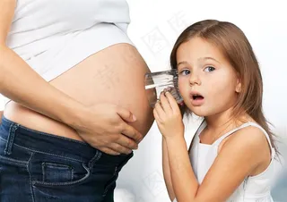 小女孩倾听孕妇胎儿摄影素材