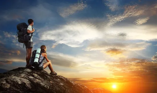 黄昏岩石上的情侣男女