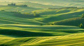 春日阳光下绿色连绵山脉草坪