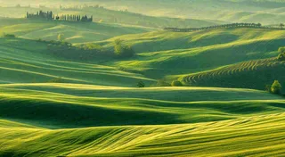 春日阳光下绿色连绵山脉草坪