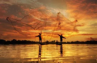 黄昏湖畔渔民炫彩天空风景图片