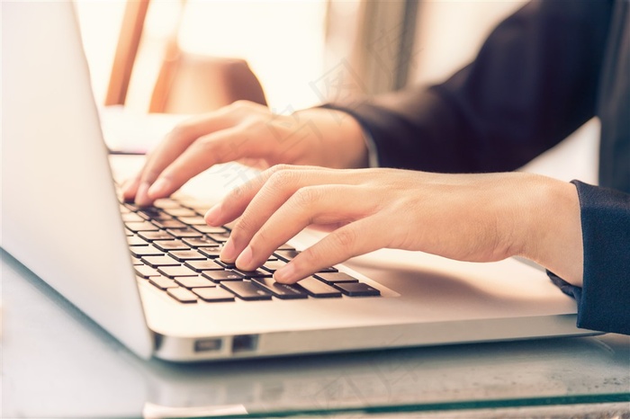 双手操作笔记本电脑的女性人物高清图片