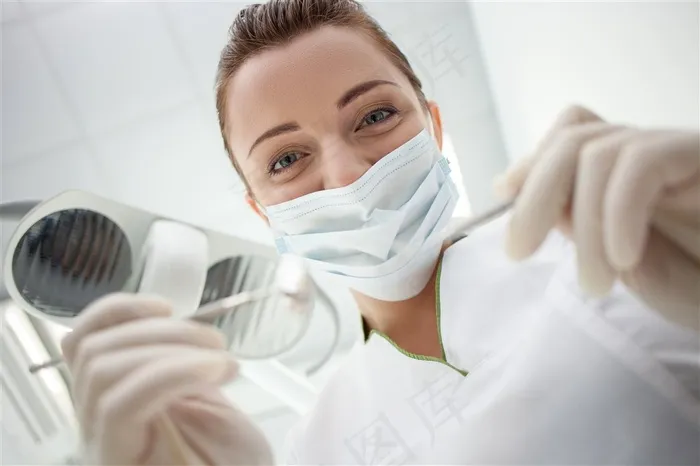 戴着口罩拿着口腔检查工具微笑的美女高清图片