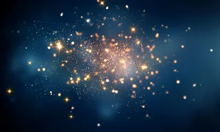 蓝色背景上的金色闪耀发光粒子背景高清图片