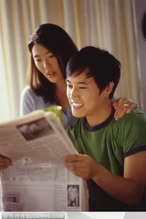 家中生活-坐一起读报纸的年轻夫妻两 家中生活-坐一起读报纸的年轻夫妻两
