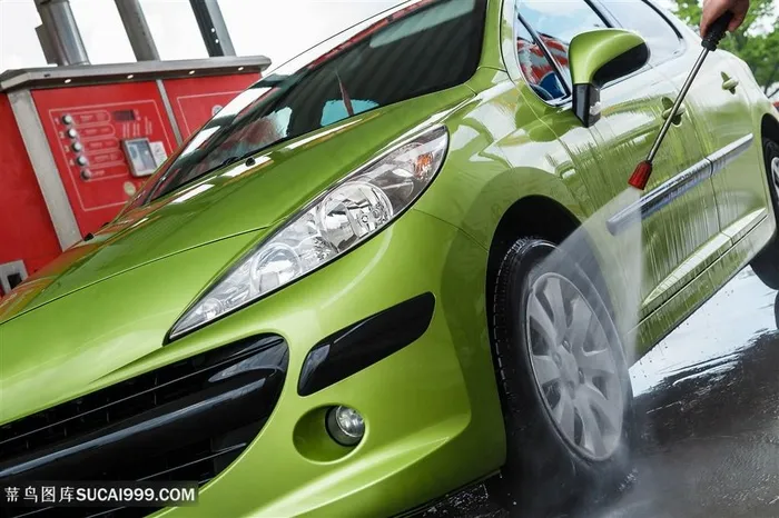 正在冲洗车轮的绿色小轿车侧面高清摄影图片