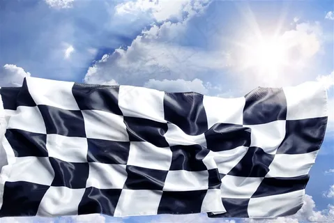 蓝天上的阳光和飘扬的黑白格旗子高清图片