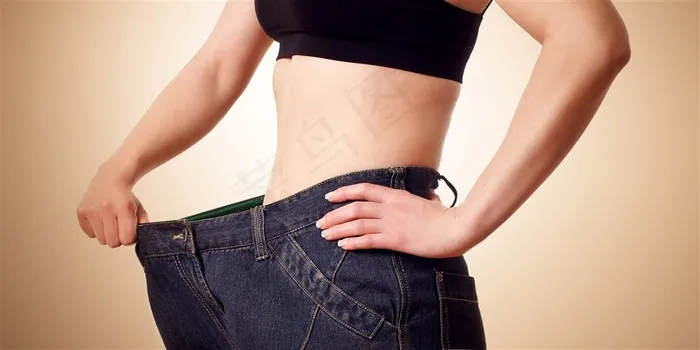 减肥成功后穿着宽大的牛仔裤的女士高清图片