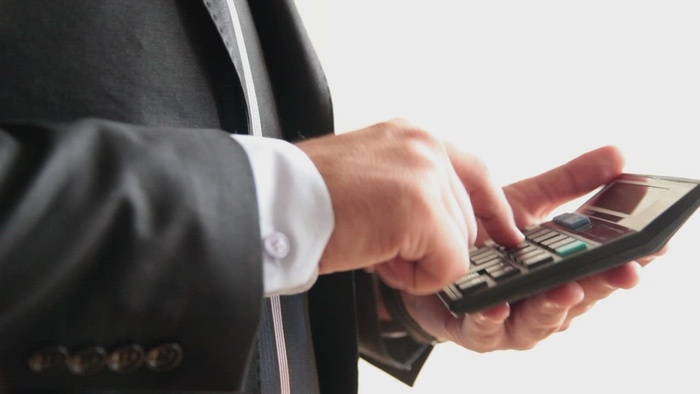 在计算器上计数的商人