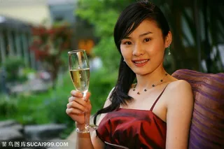 穿着晚礼服端着香槟的女性