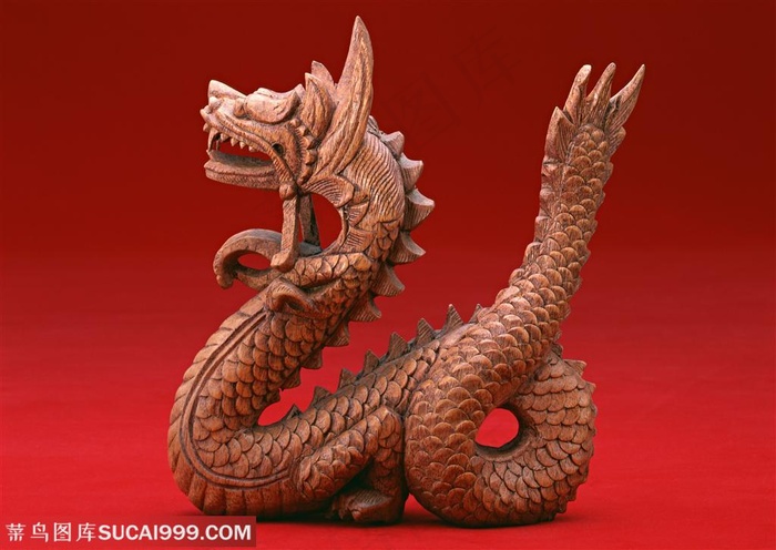 静物龙的特写-在红色背景前的木质雕刻龙的造型
