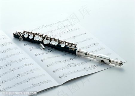 乐器-笛子放在展开的乐谱上