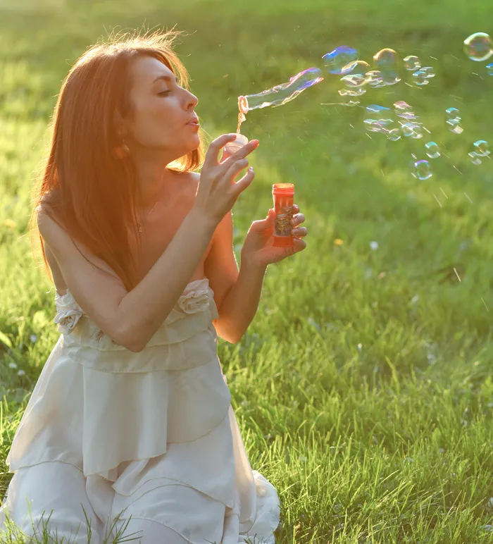 草地美女吹泡泡图片
