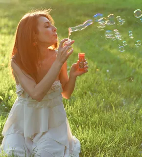 草地美女吹泡泡图片