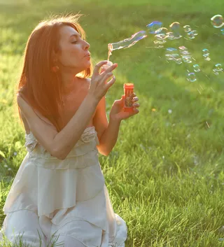 草地美女吹泡泡图片